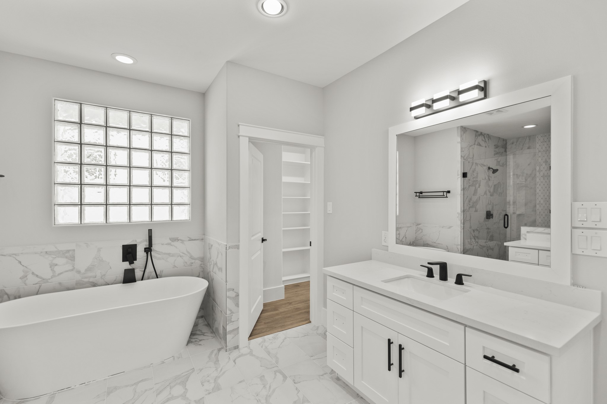 1421 West 23rd Street, Unit C Houston, TX 77008 - Photo 22 of 40 a bathroom with a double vanity sink large mirror and a bathtub