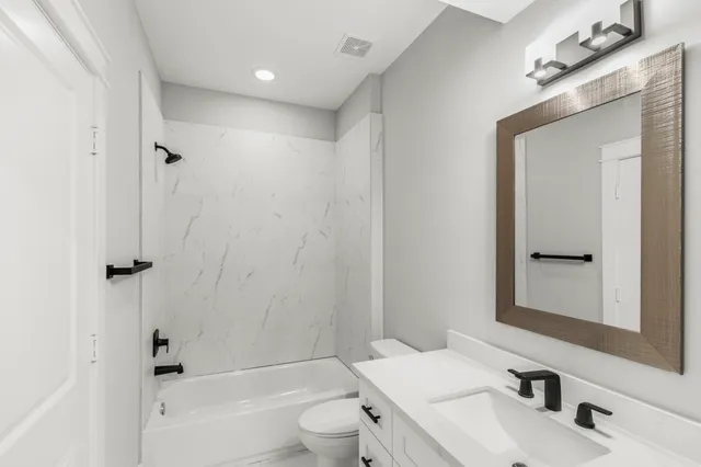 an empty room with wooden floor and ceiling fan