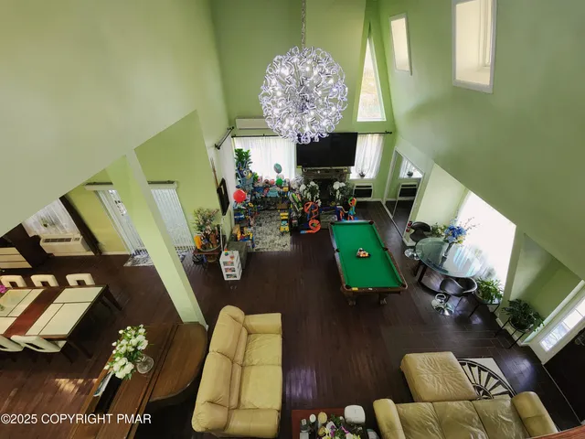 a living room with furniture a flat screen tv and a refrigerator