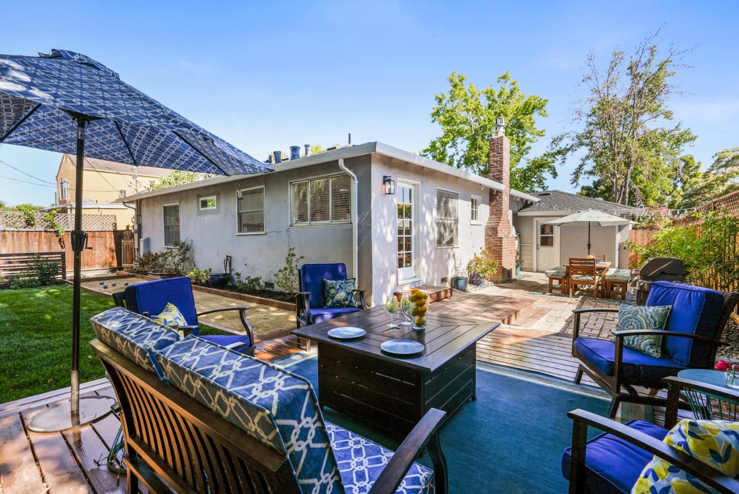 2250 Tulip Road San Jose, CA 95128 - Photo 26 of 39 a view of a patio with couches table and chairs under an umbrella with a small yard