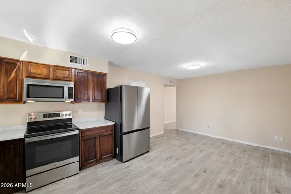 a view of an empty room with wooden floor and closet