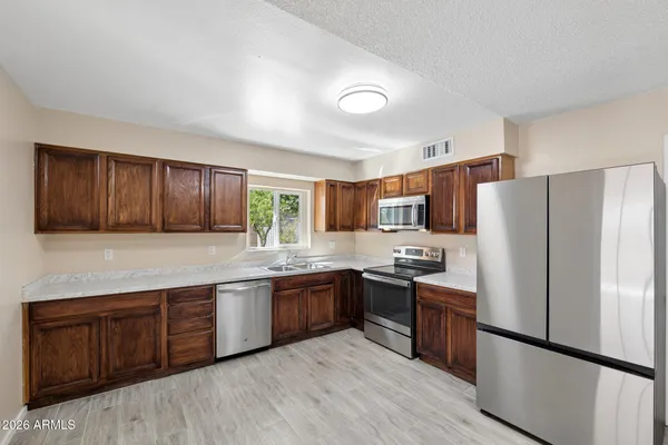 a kitchen with stainless steel appliances a refrigerator and a stove top oven