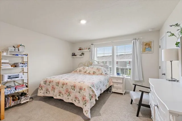 a bedroom with a bed chair and a window