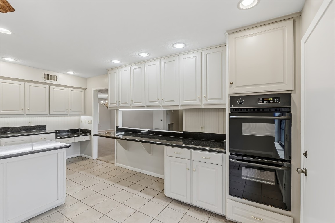 807 Standley Road Madisonville, TX 77864 - Photo 17 of 35 a kitchen with granite countertop white cabinets and stainless steel appliances