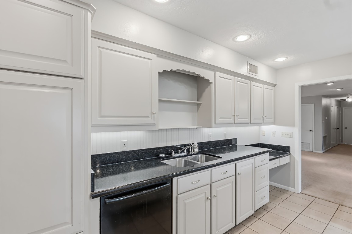 807 Standley Road Madisonville, TX 77864 - Photo 20 of 35 a kitchen with granite countertop white cabinets and black appliances