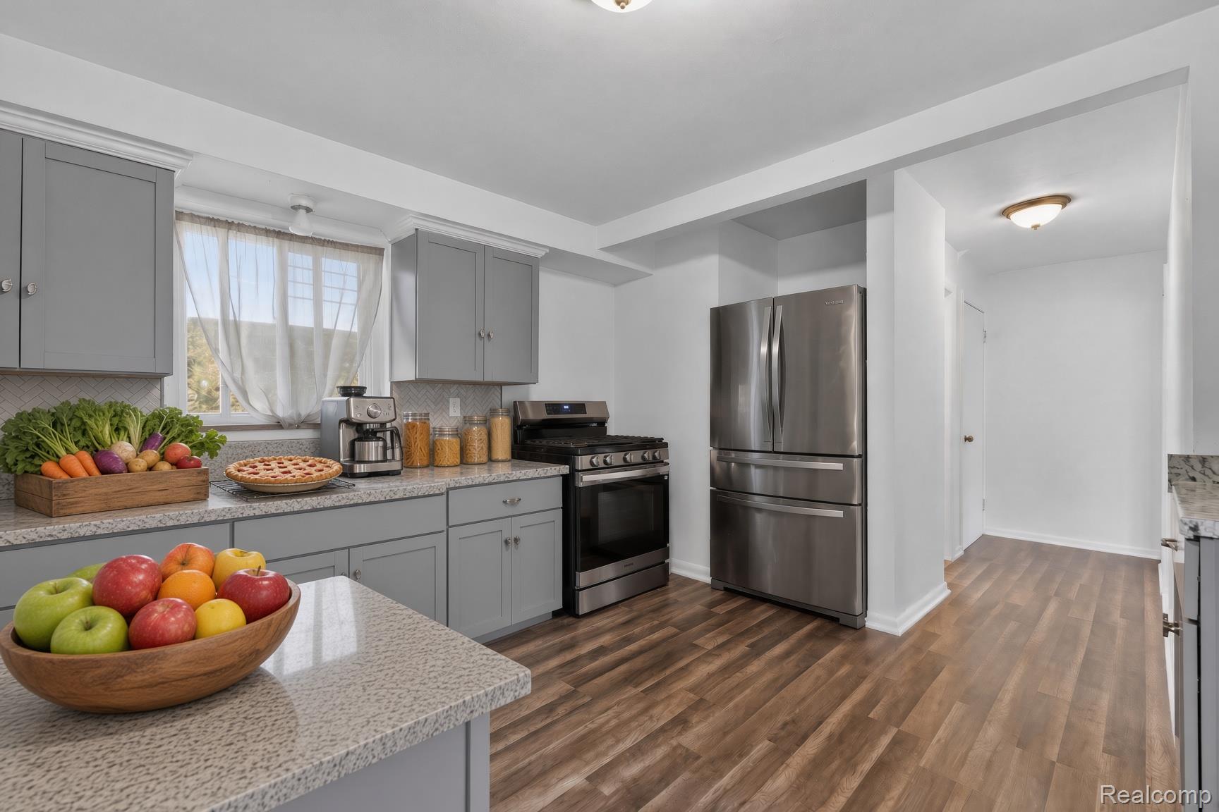 5203 Devonshire Road Detroit, MI 48224 - Photo 3 of 16 Kitchen featuring gray cabinetry, stone countertops, stainless steel appliances, wood-finish flooring, and a window