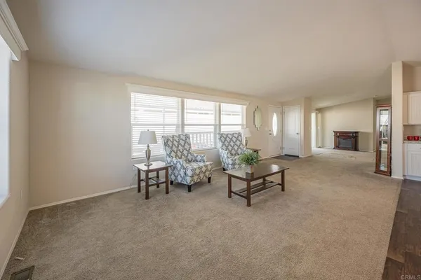 a view of an empty room with a fireplace and a window