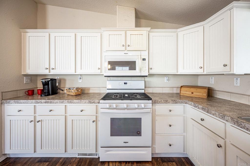 4650 Dulin Road, Unit 40 Fallbrook, CA 92003 - Photo 10 of 52 a kitchen with granite countertop white cabinets and white appliances