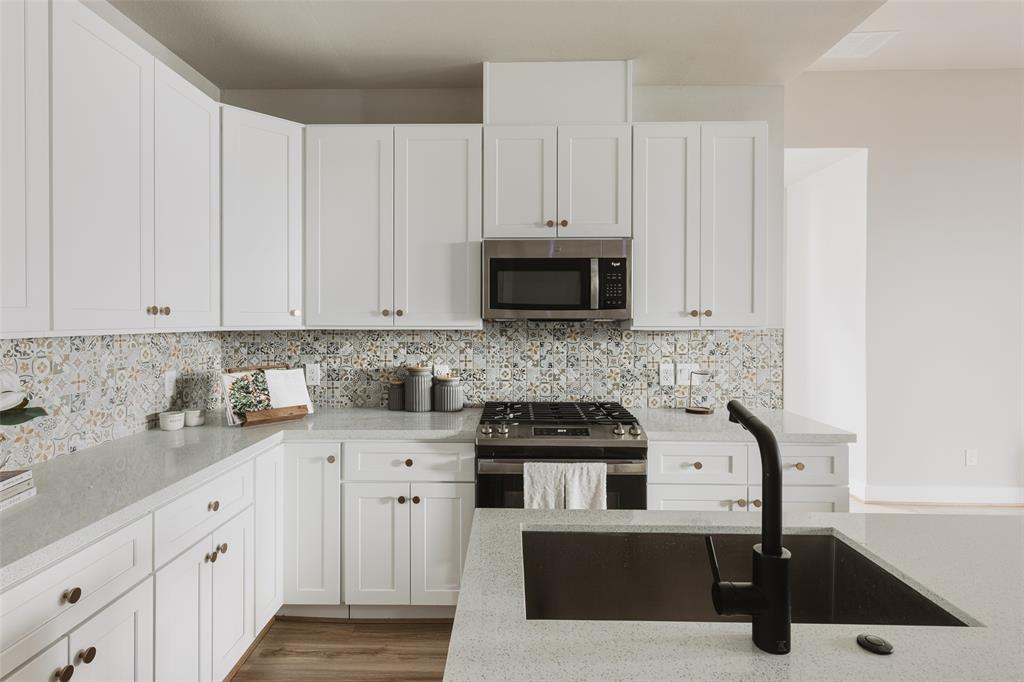 a kitchen with white cabinets a sink and white appliances