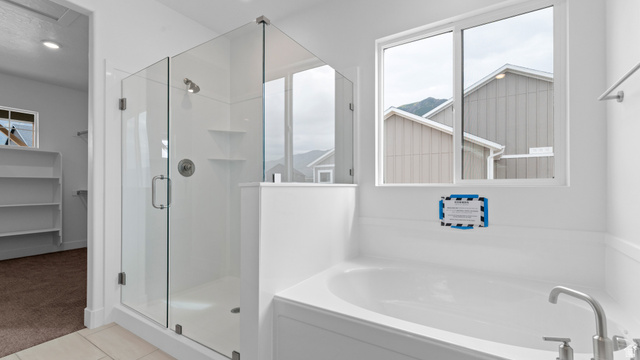 4170 North 560th West, Unit 6 Tooele, UT 84074 - Photo 11 of 20 Bathroom featuring a glass-enclosed shower, built-in soaking tub, and a window providing natural light