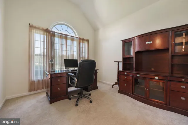 a view of a workspace with furniture and a window