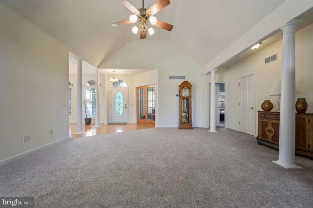 an empty room with closet and a chandelier fan