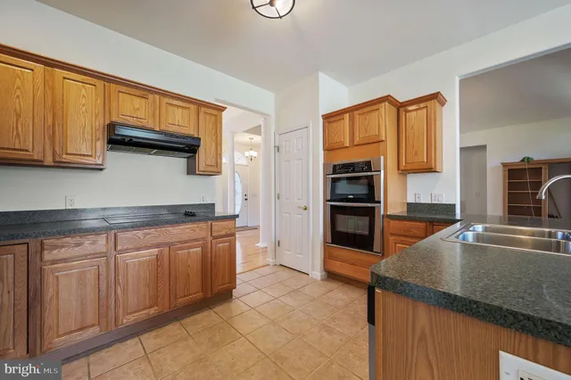 a kitchen with stainless steel appliances granite countertop a refrigerator and a stove top oven