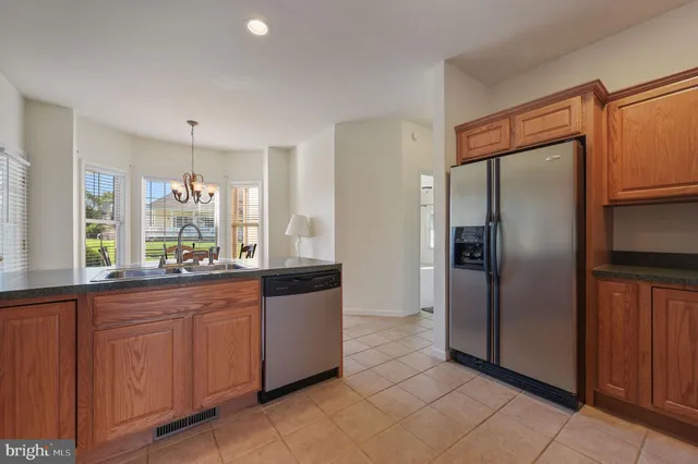 a large kitchen with granite countertop a refrigerator and a sink