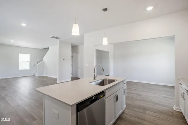 a kitchen with a sink and wooden floor