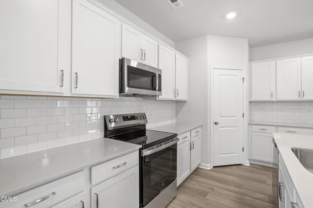 a kitchen with a sink a stove and cabinets