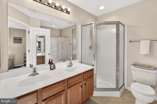 a bathroom with a shower sink vanity mirror and toilet