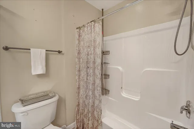 a bathroom with a shower curtain and a toilet