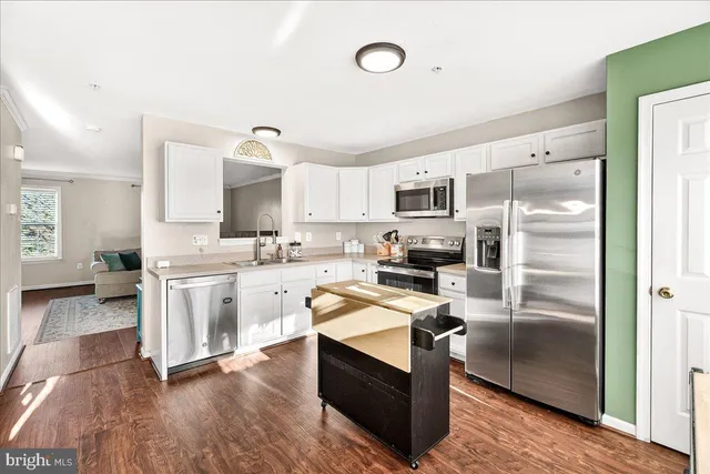 a kitchen with a refrigerator microwave and stove top oven