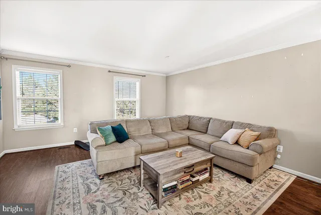 a living room with furniture and a window with wooden floor