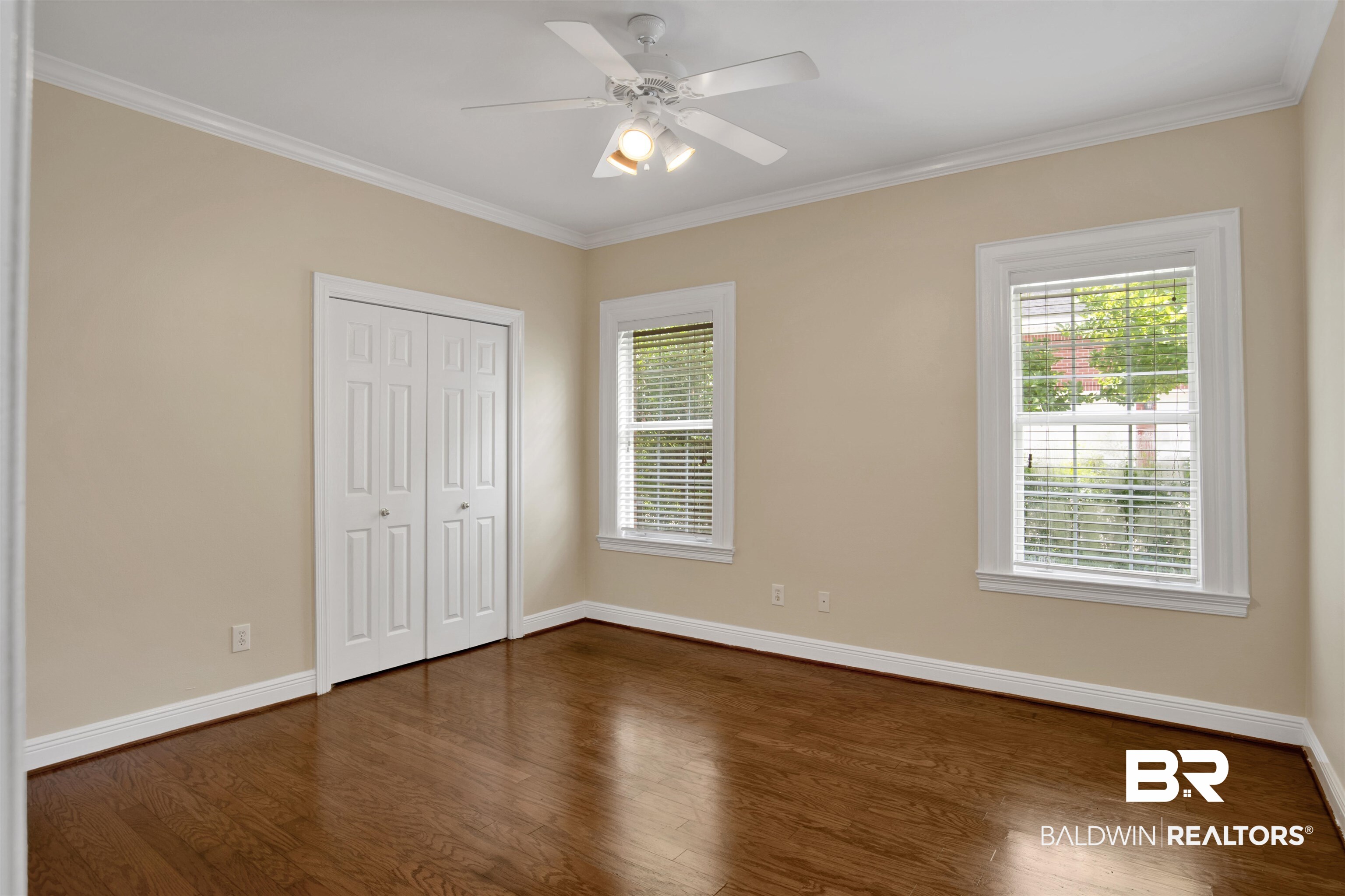 8847 Dawes Lake Road South Mobile, AL 36619 - Photo 27 of 47 Room featuring rich wood-finish flooring, crisp white baseboards and crown molding, and two windows with blinds