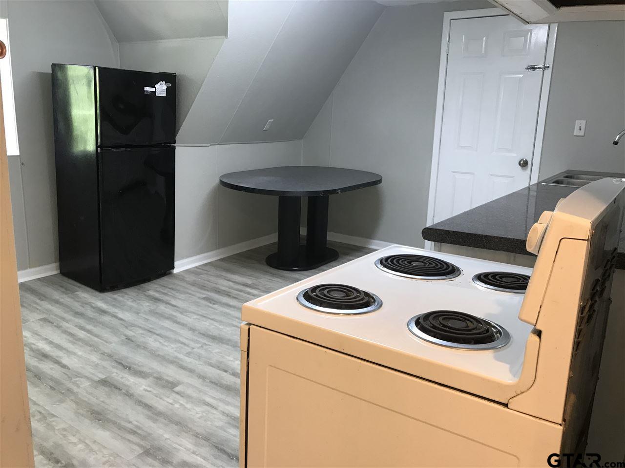 208 West Phillips Street, Unit 300 Tyler, TX 75701 - Photo 12 of 12 a kitchen with a stove and a refrigerator