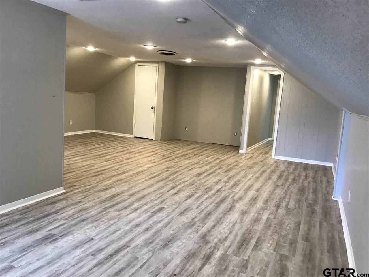208 West Phillips Street, Unit 300 Tyler, TX 75701 - Photo 2 of 12 an empty room with wooden floor and natural light