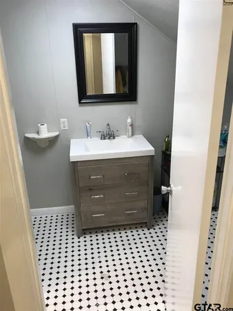 a bathroom with a sink vanity and mirror