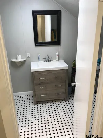 a bathroom with a sink vanity and mirror