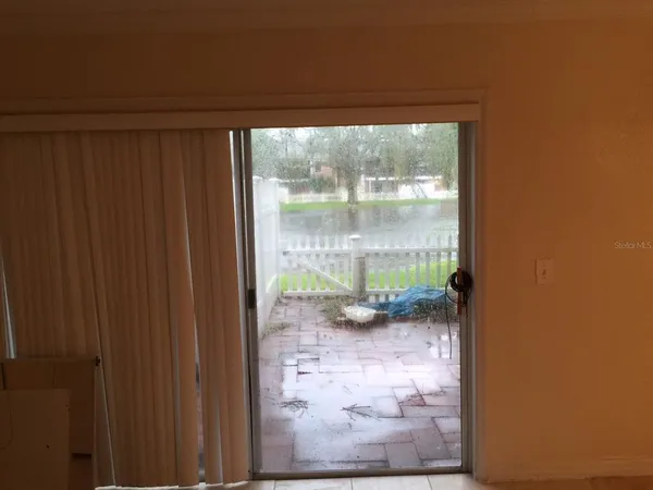 a view of a glass door and porch next to a yard