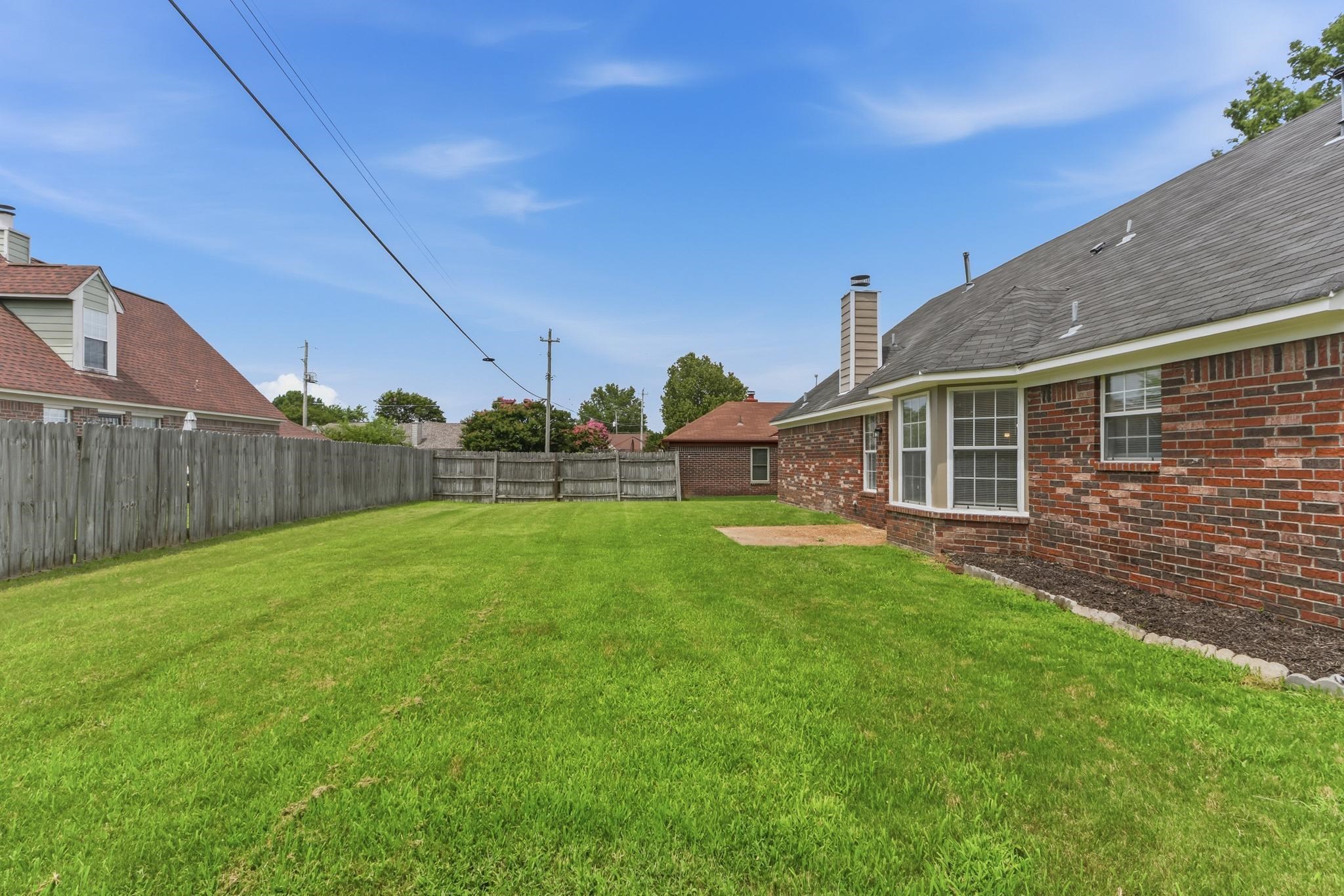 4101 Long Creek Road Memphis, TN 38125 - Photo 33 of 36 Expansive green lawn surrounded by a wooden privacy fence