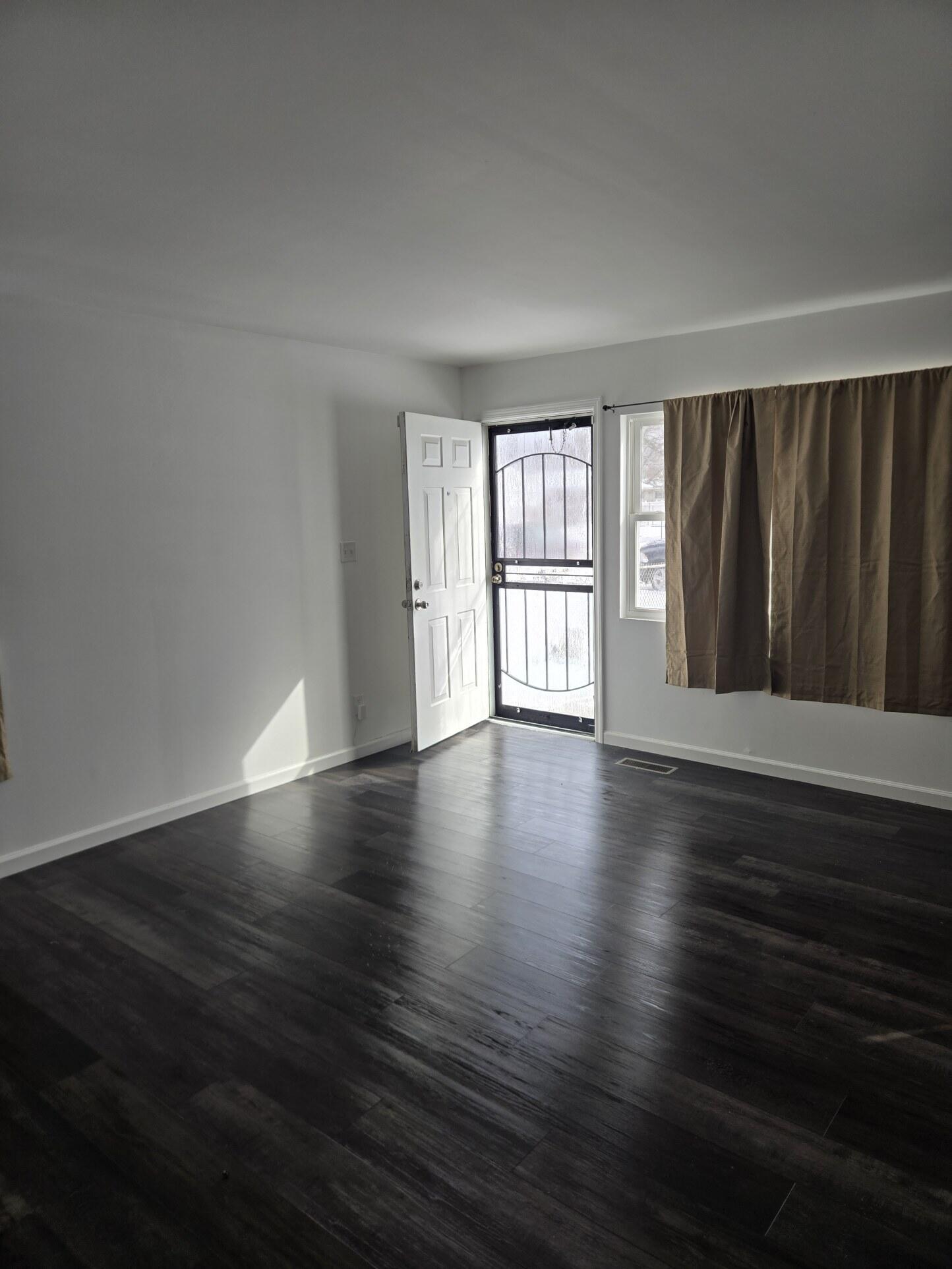 1932 Arthur Street Gary, IN 46404 - Photo 2 of 14 a view of an empty room with wooden floor and a window