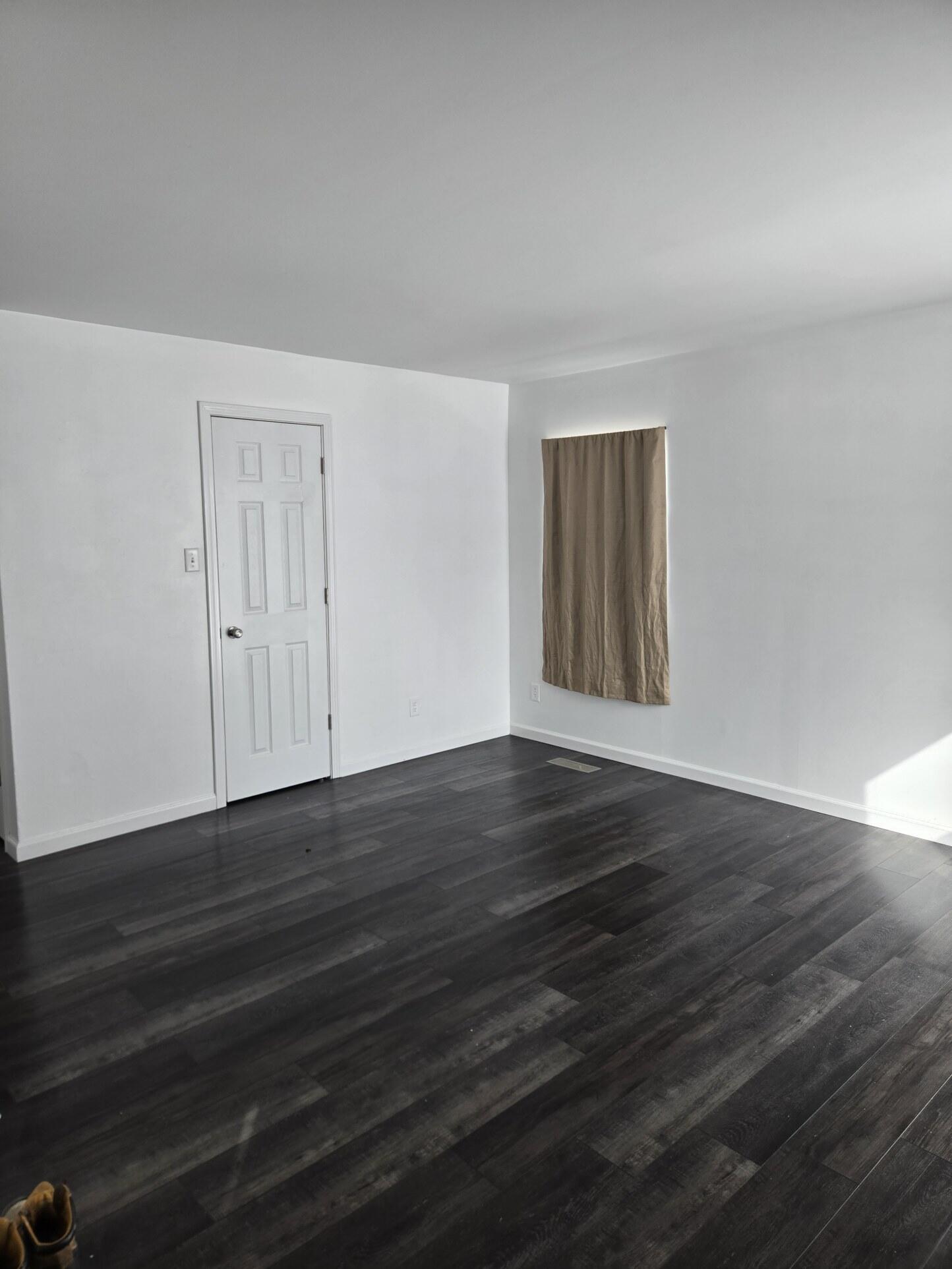 1932 Arthur Street Gary, IN 46404 - Photo 3 of 14 a view of an empty room with wooden floor and a window