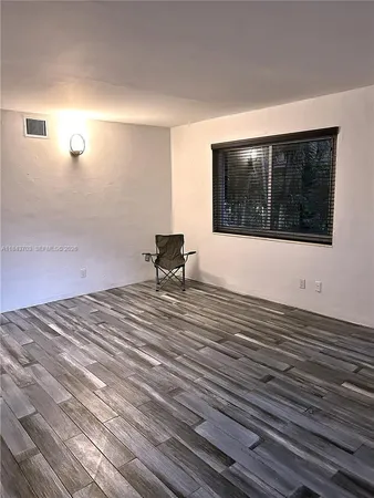 a view of a livingroom with wooden floor and furniture