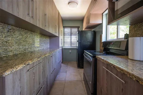 a kitchen with stainless steel appliances granite countertop a refrigerator a stove and a sink