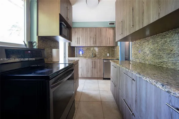 a kitchen with stainless steel appliances granite countertop a sink stove and cabinets