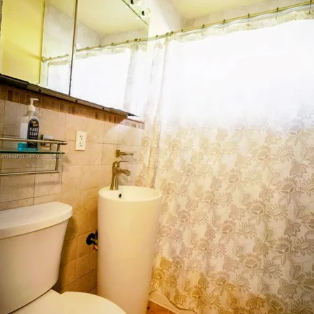 a bathroom with a toilet sink and shower