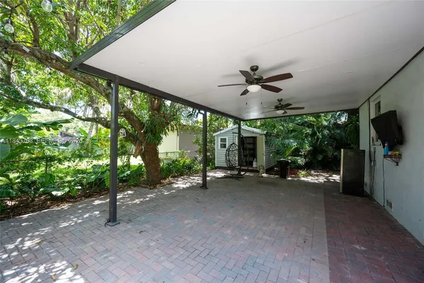 a view of a big room with windows and ceiling fan