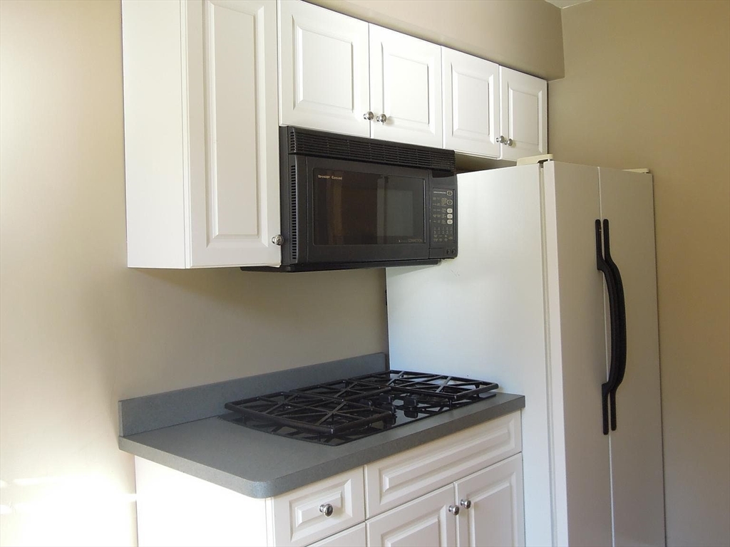 8 Garrison Street, Unit 209 Boston, MA 02116 - Photo 13 of 33 a kitchen with granite countertop a stove and a microwave