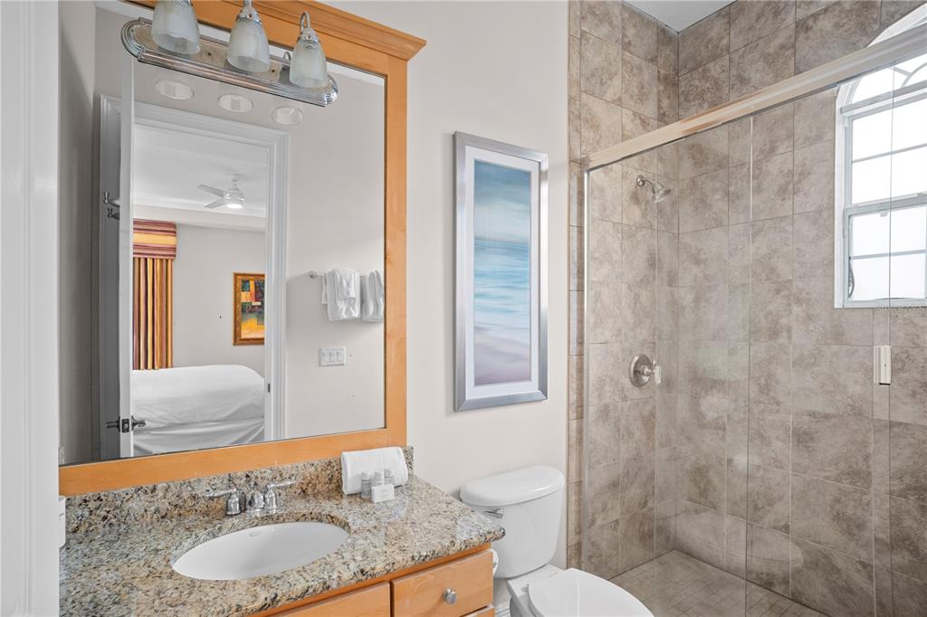 7388 Gathering Court Reunion, FL 34747 - Photo 43 of 56 a bathroom with a granite countertop sink toilet and shower