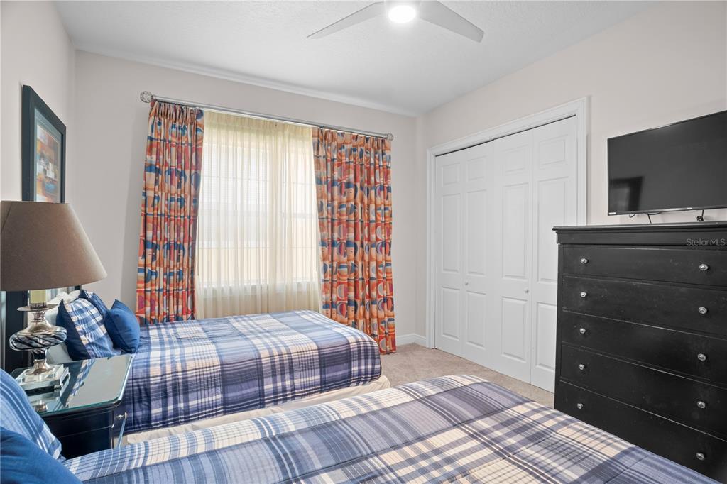 7388 Gathering Court Reunion, FL 34747 - Photo 45 of 56 a bedroom with a bed and a flat tv screen on a dresser