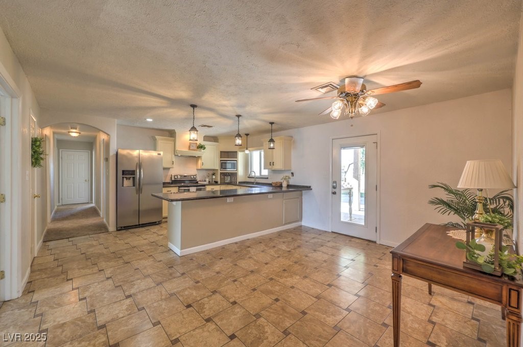 3811 Skyline Street Logandale, NV 89021 - Photo 9 of 58 Kitchen featuring appliances with stainless steel finishes, arched walkways, and hanging light fixtures over the island