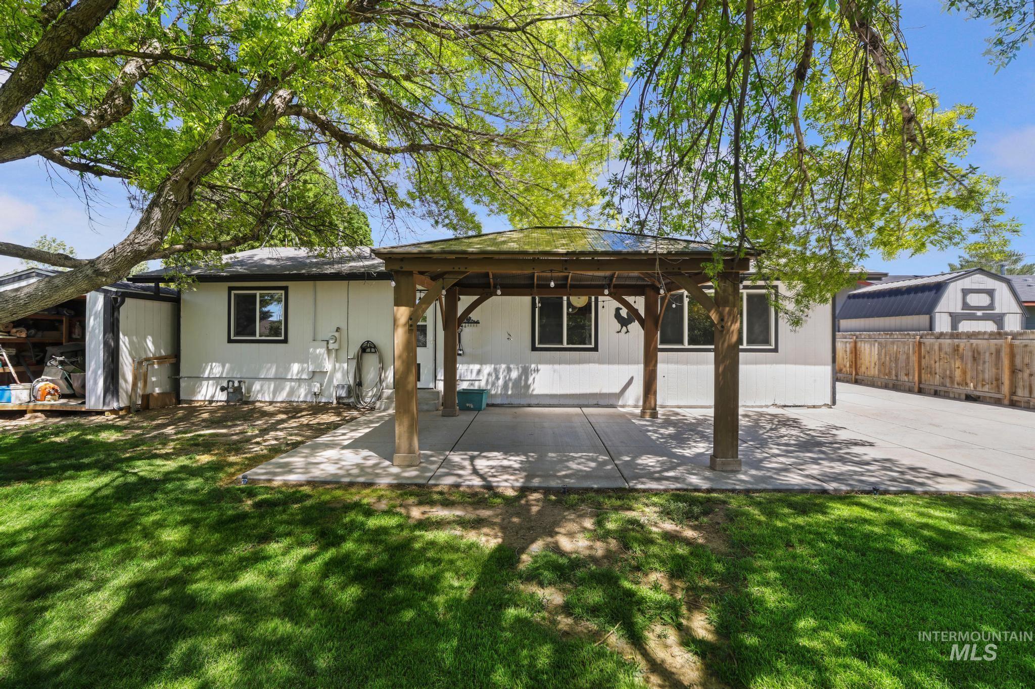 712 Locust Street Kimberly, ID 83341 - Photo 3 of 26 Property featuring a dark shingle roof, concrete driveway, and mature landscaping