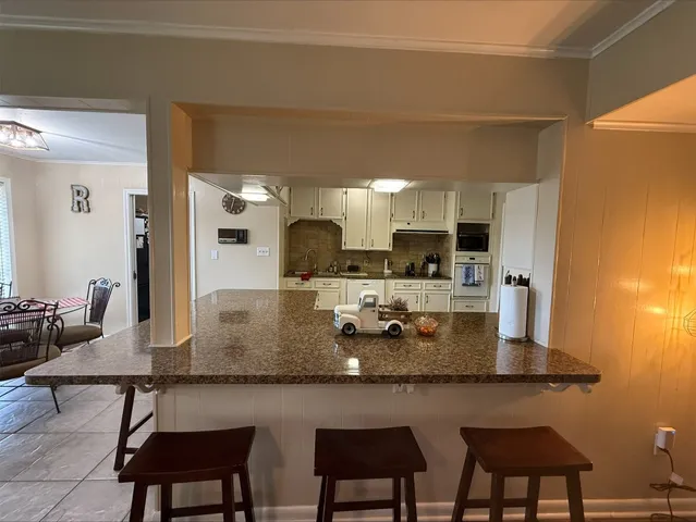 a kitchen with cabinets table and chairs