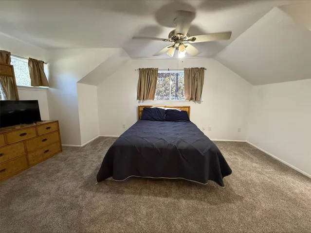 a spacious bedroom with a bed and a flat screen tv