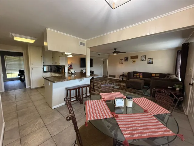 a living room with lots of furniture and kitchen view