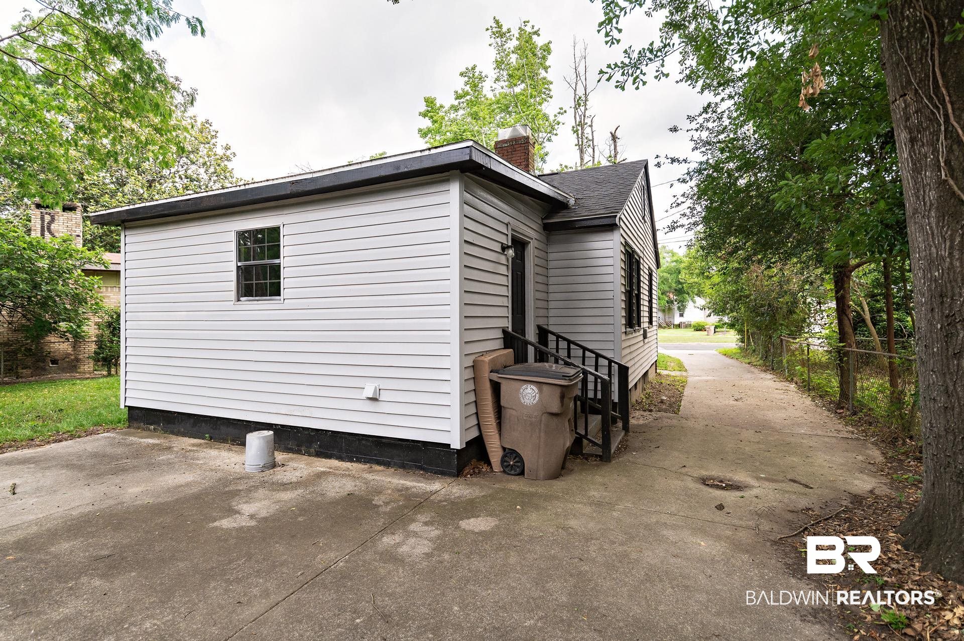 1869 Mott Drive West Mobile, AL 36617 - Photo 28 of 34 View of side of property with a chimney, entry steps, fence, and a patio area
