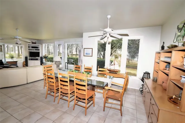 a dining room with furniture a chandelier and kitchen view