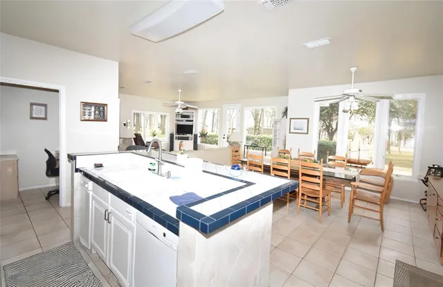 a large white kitchen with a table and chairs in it