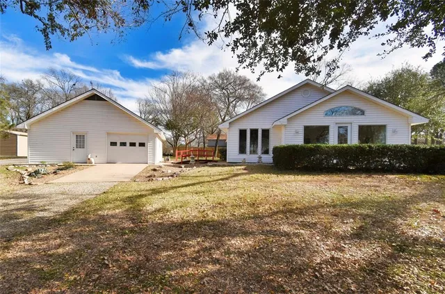 a view of a house with a yard and large tree